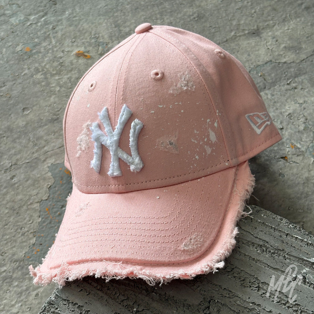 Pink Raw Edge custom New Era New York Yankees cap featuring a distressed white embroidered NY logo, frayed raw-edge brim, distressed detailing and a soft pink hand-customised finish.