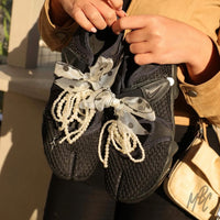 Black Nike Air Rift trainers with sheer polka dot ribbon laces, pearl lace charms and decorative sneaker accessories