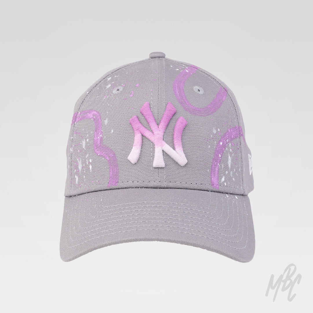 Gradient Swipe custom New Era NY cap featuring a hand-painted pink gradient logo, abstract purple paint swipes and white paint splatter detailing.