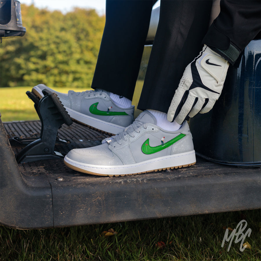 Putting Swoosh Nike Jordan 1 Low Golf Custom Sneakers in grey in Golf Buggy on Golf Course