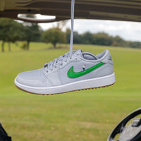 Putting Swoosh Nike Jordan 1 Low Golf Custom Sneakers in grey in Golf Buggy on Golf Course