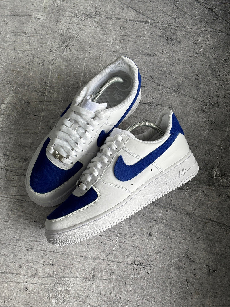 Custom Nike Air Force 1 featuring royal blue fabric overlays and cut and sew detailing for unique personalised trainers