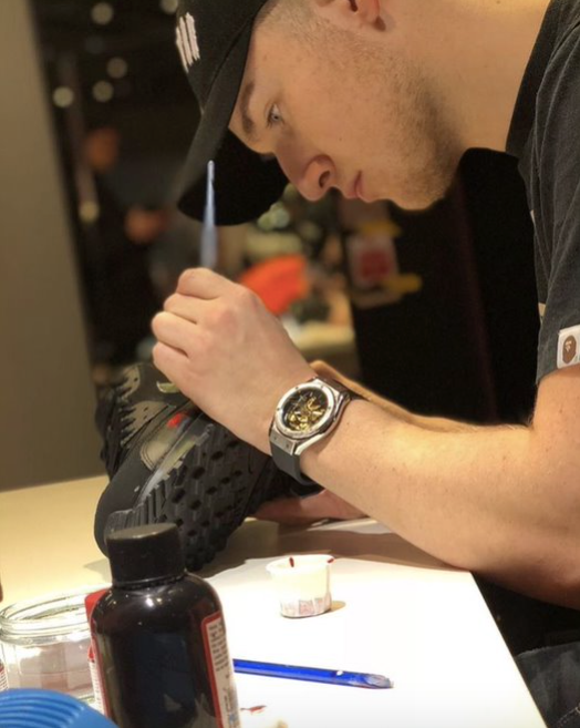Hand painting custom Air Max trainers at an Offspring store in Selfridges