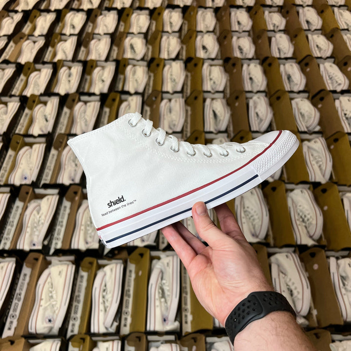 branded white converse trainers with shield vinyl logo