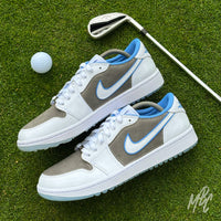 Slate Suede custom Jordan 1 Low Golf shoes featuring grey suede panels, white leather and light blue accents, photographed on a golf green with a golf club and ball.