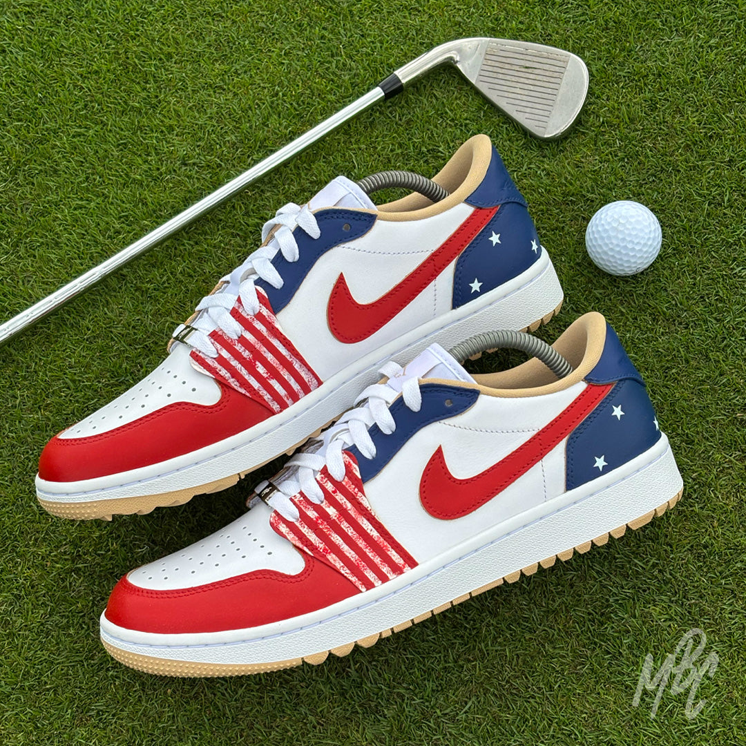 Stateside Drive custom Jordan 1 Low Golf shoes featuring hand-painted USA-inspired red, white and blue on a golf course with a golf club and ball.