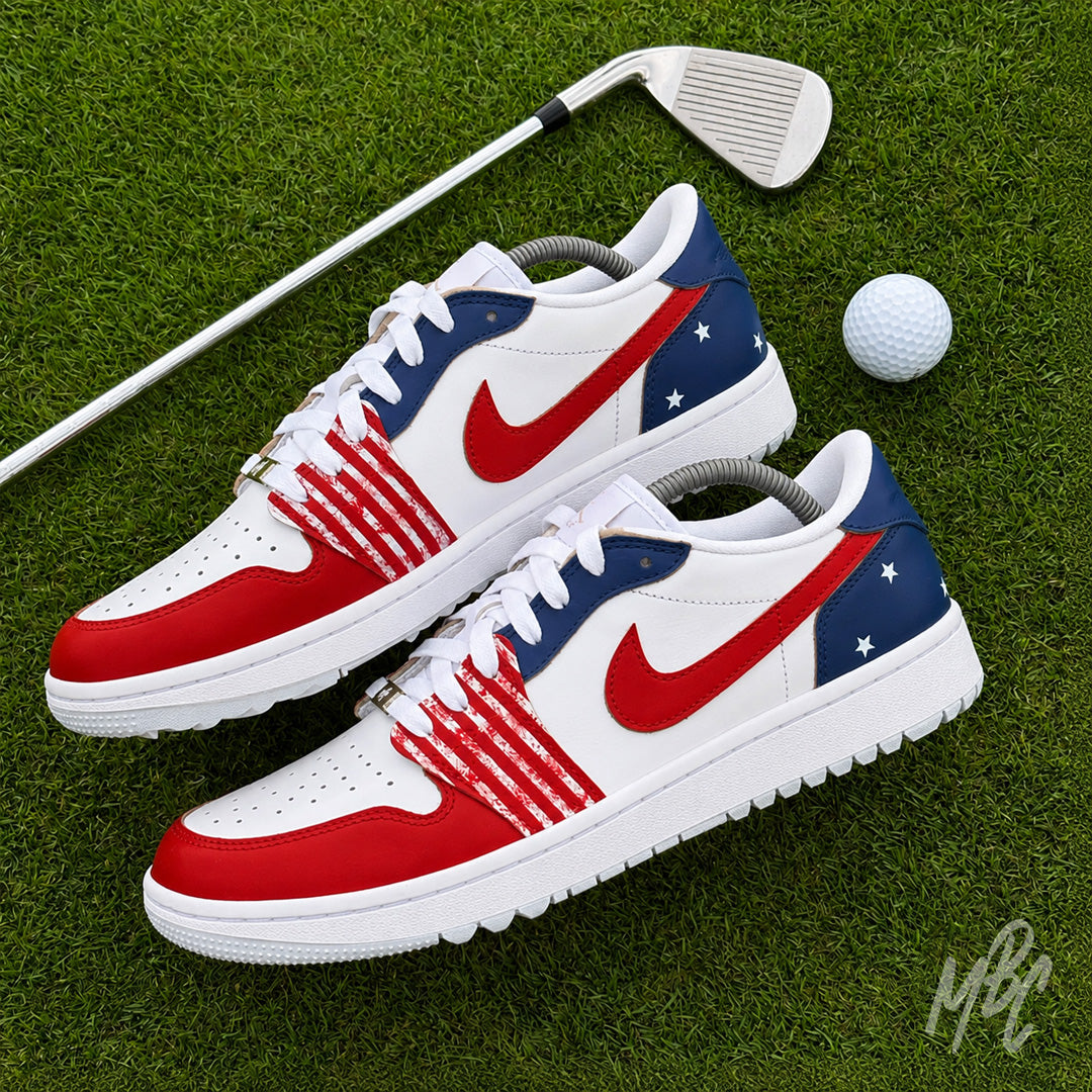 Stateside Drive custom Jordan 1 Low Golf shoes featuring hand-painted USA-inspired red, white and blue on a golf course with a golf club and ball.