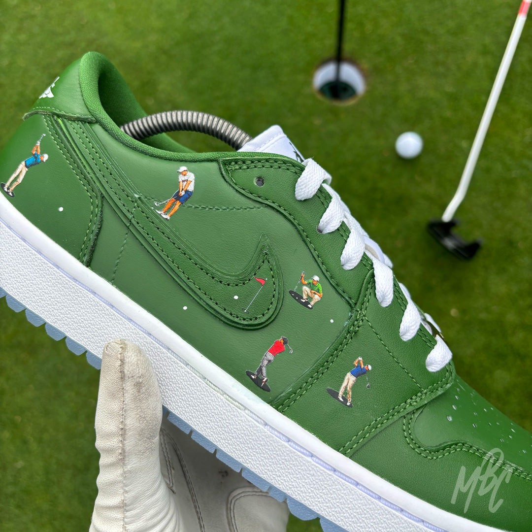 Close-up of the Sunday Club custom Jordan 1 Low Golf shoes featuring hand-painted green leather, heat-pressed golfer illustrations and golf flag details on a golf course putting green.