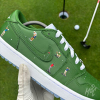 Close-up of the Sunday Club custom Jordan 1 Low Golf shoes featuring hand-painted green leather, heat-pressed golfer illustrations and golf flag details on a golf course putting green.