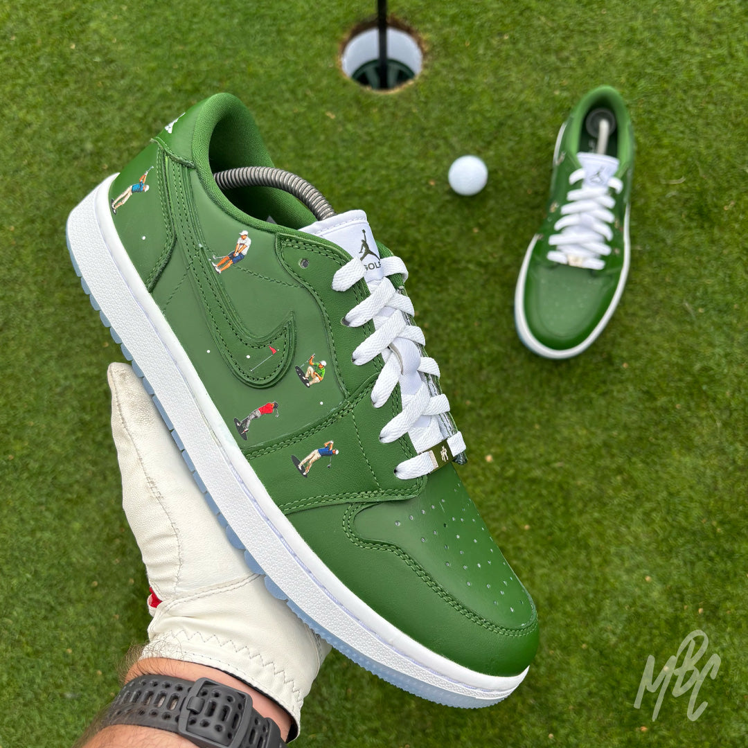 Sunday Club custom Jordan 1 Low Golf shoes held above a putting green, featuring hand-painted green leather, heat-pressed golfer illustrations and a white golf ball in the background.