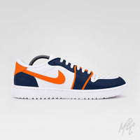 Side profile of a white Air Jordan 1 Low Golf shoe with navy overlays, bright orange accents and Nike Swoosh, white laces, and a white sole.