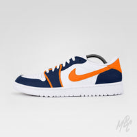 Opposite side profile of a white Air Jordan 1 Low Golf shoe featuring navy overlays, bright orange accents and Nike Swoosh, white laces, and a white sole.