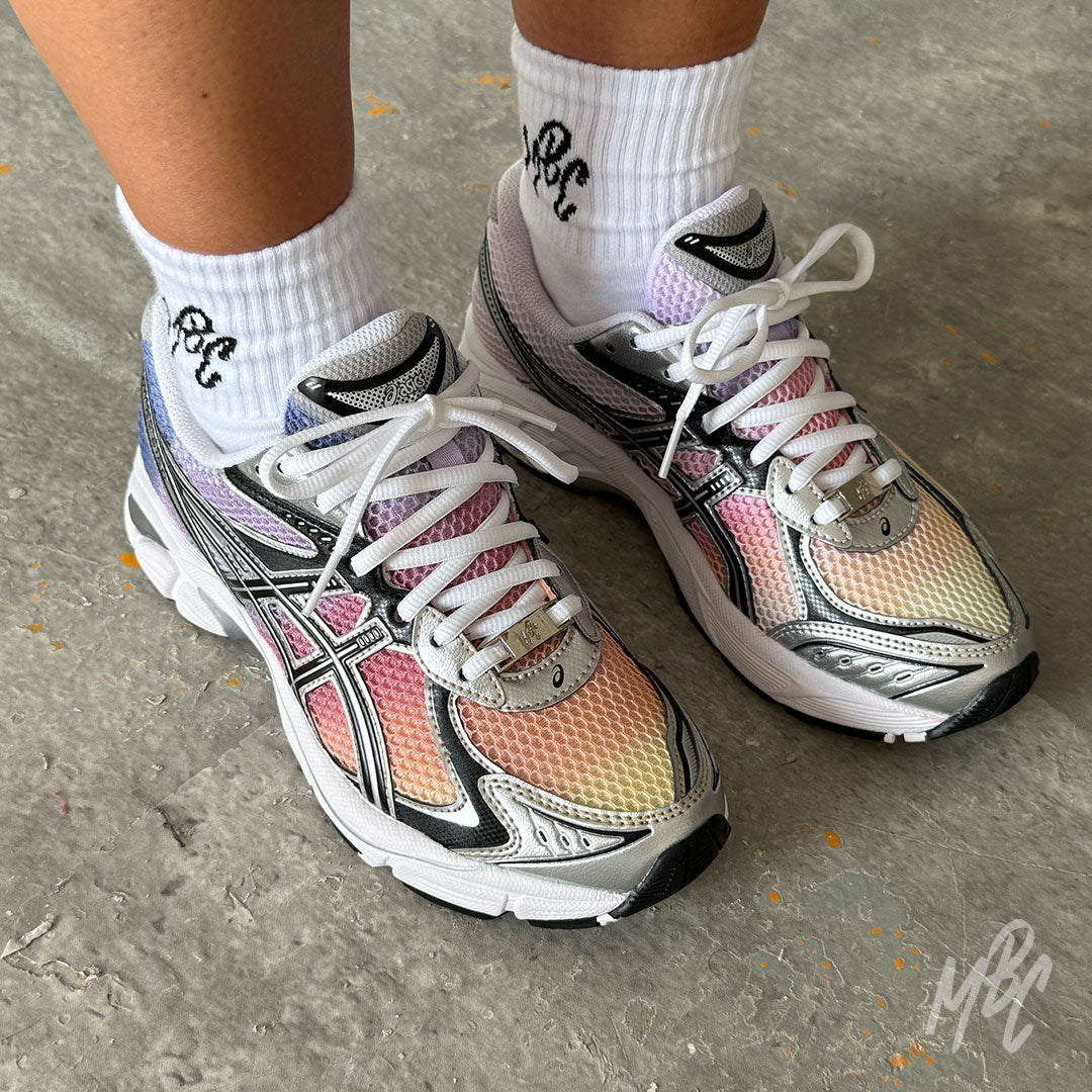 Pair of Sunset Dip Dye ASICS GT-2160 custom running trainers showcasing a hand-painted sunset gradient from yellow and orange through pink to purple on the mesh upper.