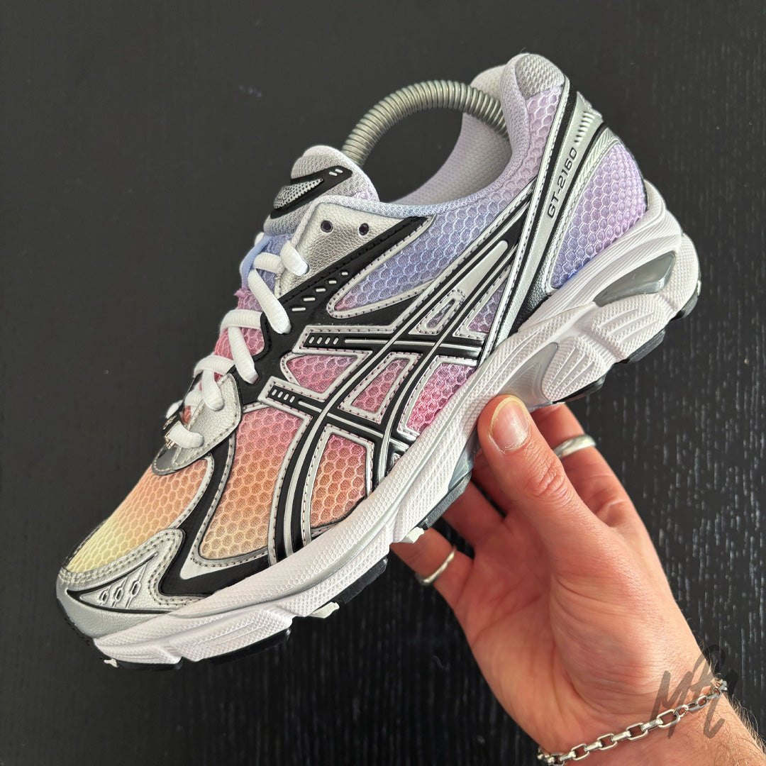 Hand-painted Asics GT-2160 Sunset Dip Dye custom sneaker with pastel colour fade design held in hand