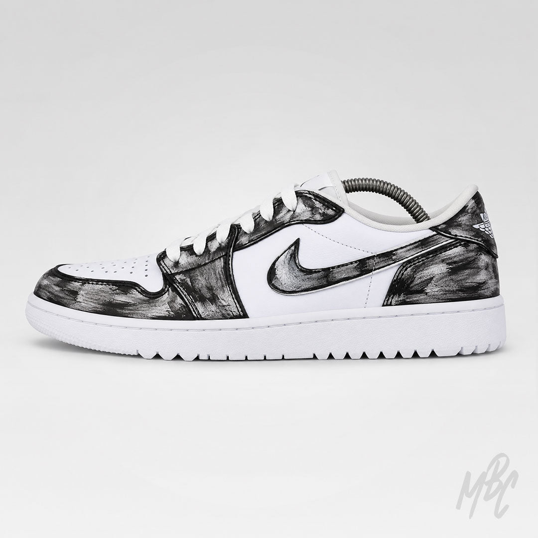 A Nike Air Jordan 1 Low sneaker in white leather with black brushstroke patterned overlays, shown in a side profile on a light gray background.