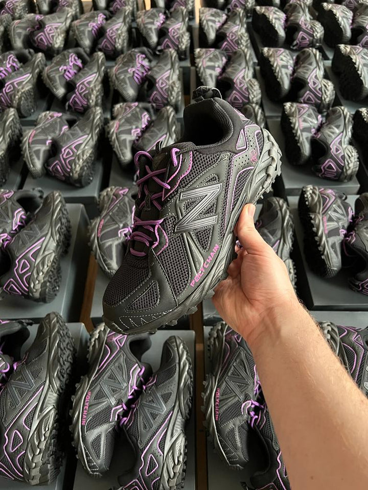 Bulk order of black New Balance 610 custom sneakers with purple Polychain branding