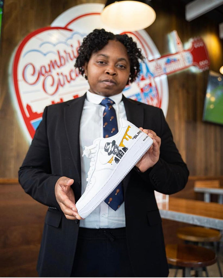 Chicken Connoisseur holding custom white Nike Air Force 1 sneaker with hand painted Slim Chickens branding