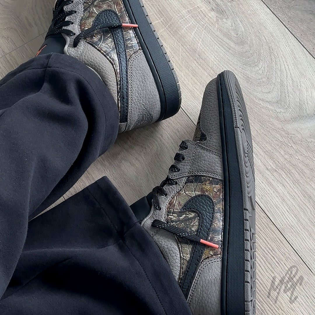 Woodland Camo Jordan 1 Low on foot side view with woodland camo panels and black swoosh