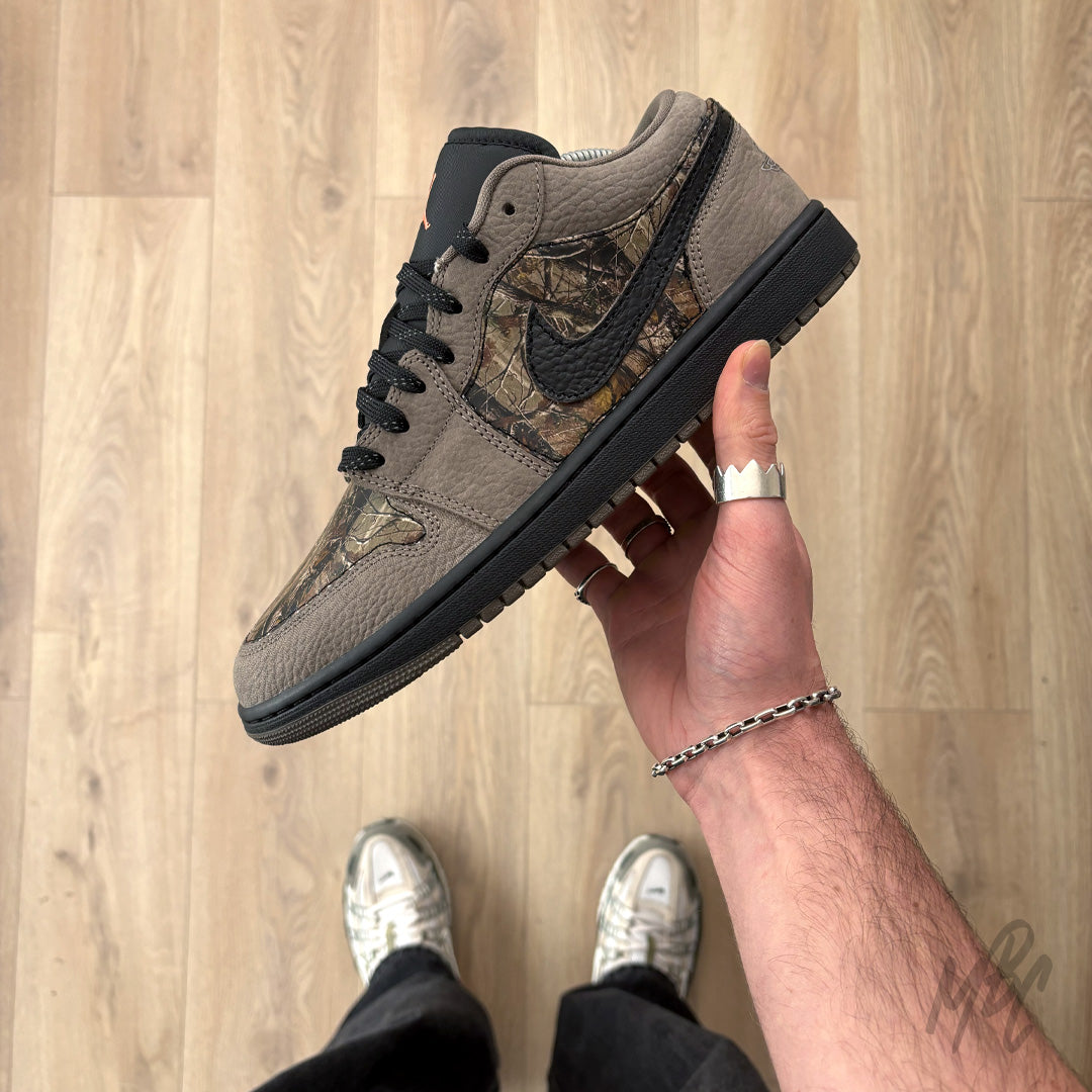 Woodland Camo Jordan 1 Low custom held in hand with brown suede overlays and black midsole