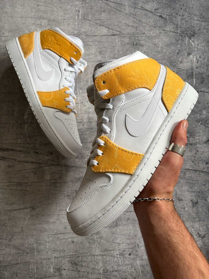 Custom Nike Jordan 1 Mid with yellow patterned fabric overlays created using cut and sew sneaker customisation techniques