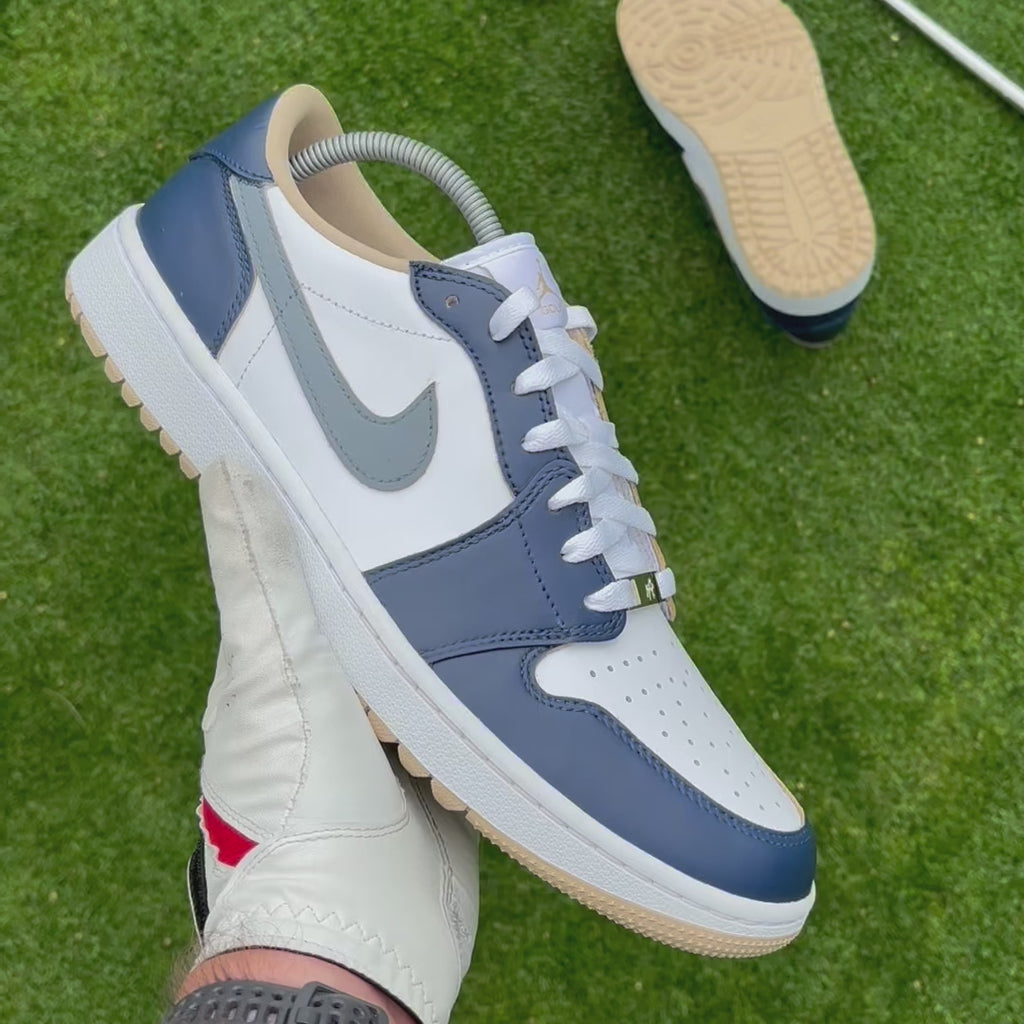 Midnight Tour custom Jordan 1 Low Golf shoes with hand-painted navy, grey and white leather panels showcased on a golf course.